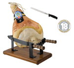 Un Prosciutto di Parma DOP invecchiato per 18 mesi, presentato su una morsa, con un coltello incluso. Rappresenta la dolcezza del gusto e la tradizione artigianale delle colline parmensi.