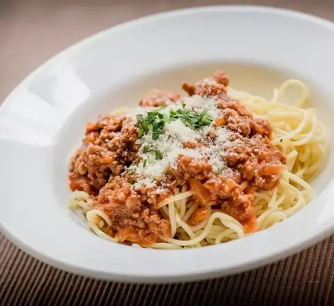 Deliciosos espaguetis bañados en una salsa de carne piamontesa, enriquecida con queso rallado y una pizca de perejil.
