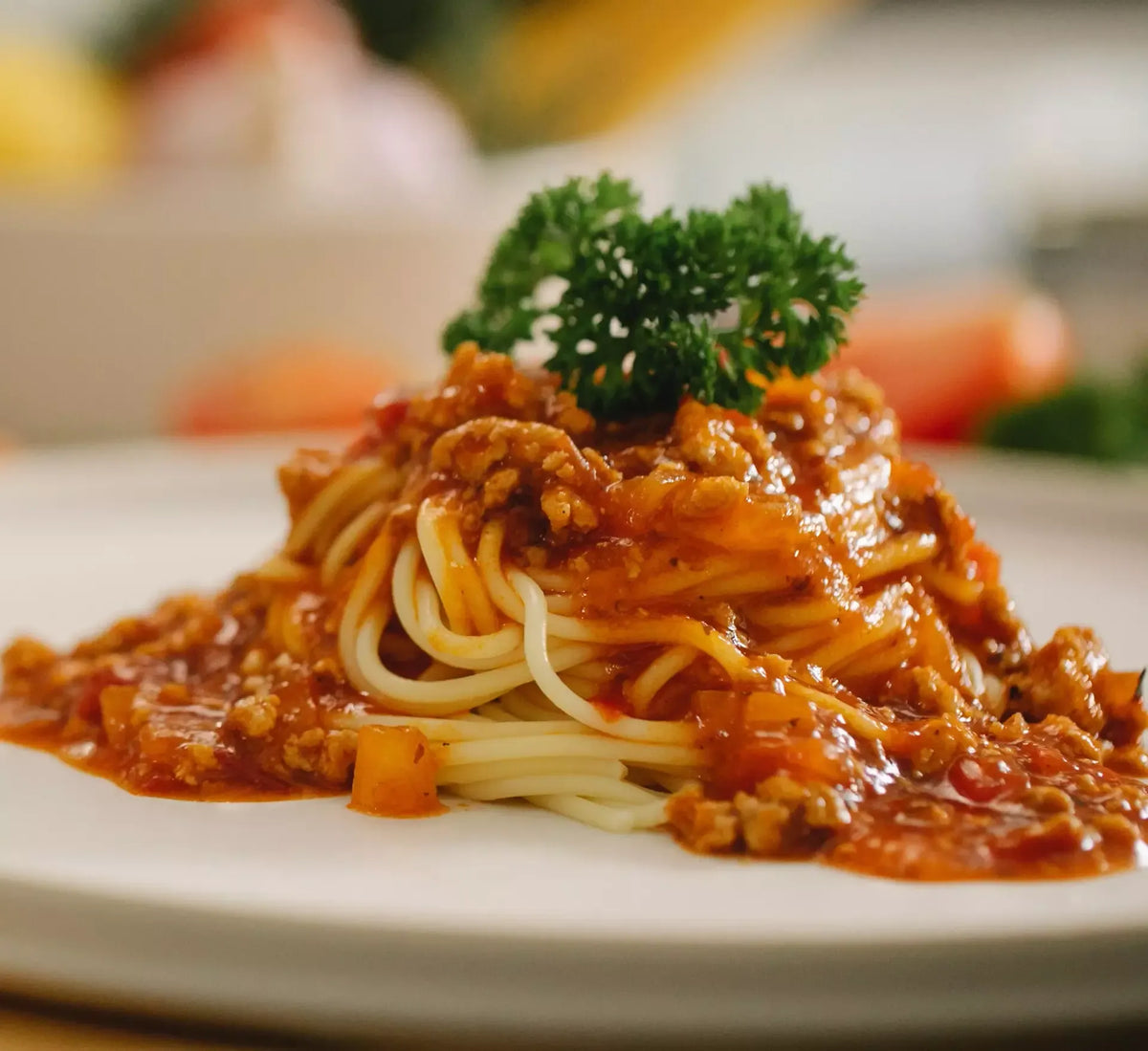 Un suntuoso plato de espaguetis en salsa de carne piamontesa, ricos en carne y verduras, enriquecidos con perejil, listos para degustar.