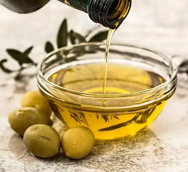 Extra vergine di qualità, olio DOP Taggiasche, versato con grazia in una ciotola, accanto a gustose olive; un assaggio autentico della Riviera Ligure.