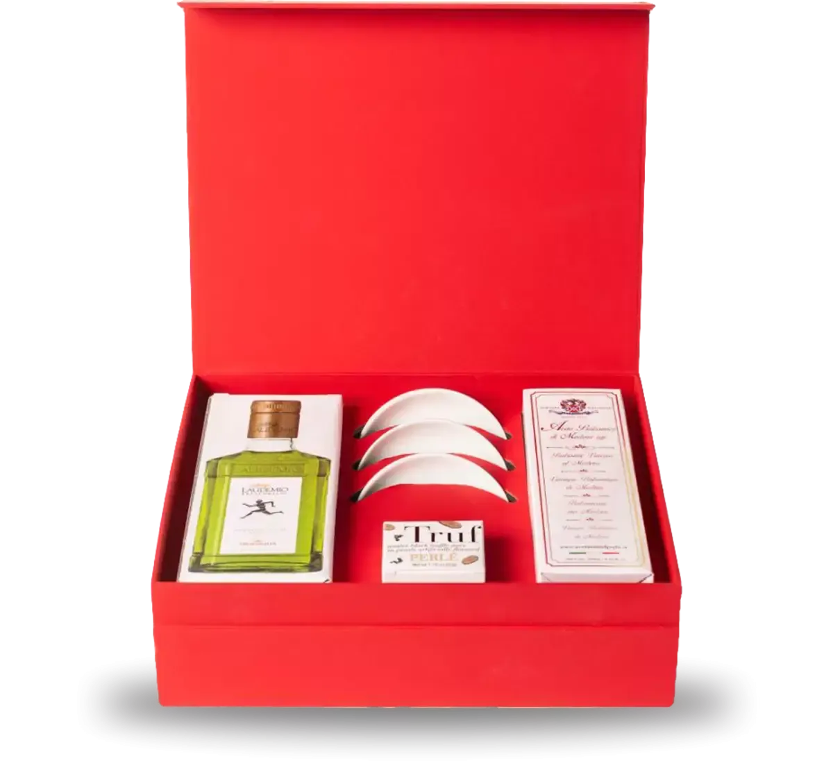Un vistazo a la caja "Il Pinzimonio", abierta y revelando aceite, trufa y vinagre, presentados sobre un vibrante fondo rojo. Los elegantes platillos de porcelana completan la escena.