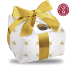 Imagen de un fino pastel de panettone hecho a mano, adornado con un lazo dorado, con el aroma único del Vinagre Balsámico de Módena IGP.