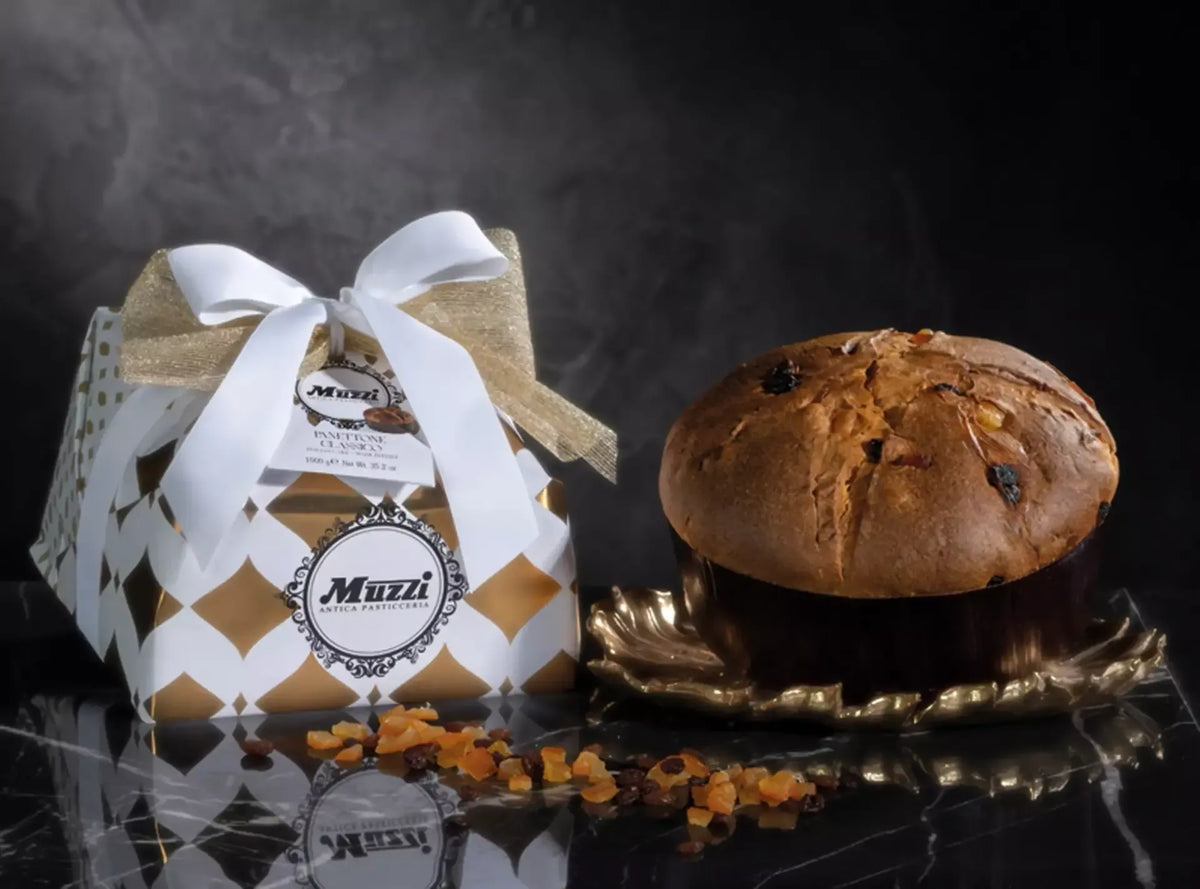 Ein goldfarbener Panettone, angereichert mit kandierten Früchten, ist sorgfältig in handgefertigte, elegante Verpackung eingewickelt und auf einem dekorativen Teller angerichtet, wodurch eine festliche und raffinierte Atmosphäre entsteht.