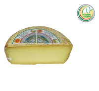 It shows a mature Pecorino Toscano PDO, cut in half. The rind is golden and the inside is straw yellow, with an intense and fragrant taste.