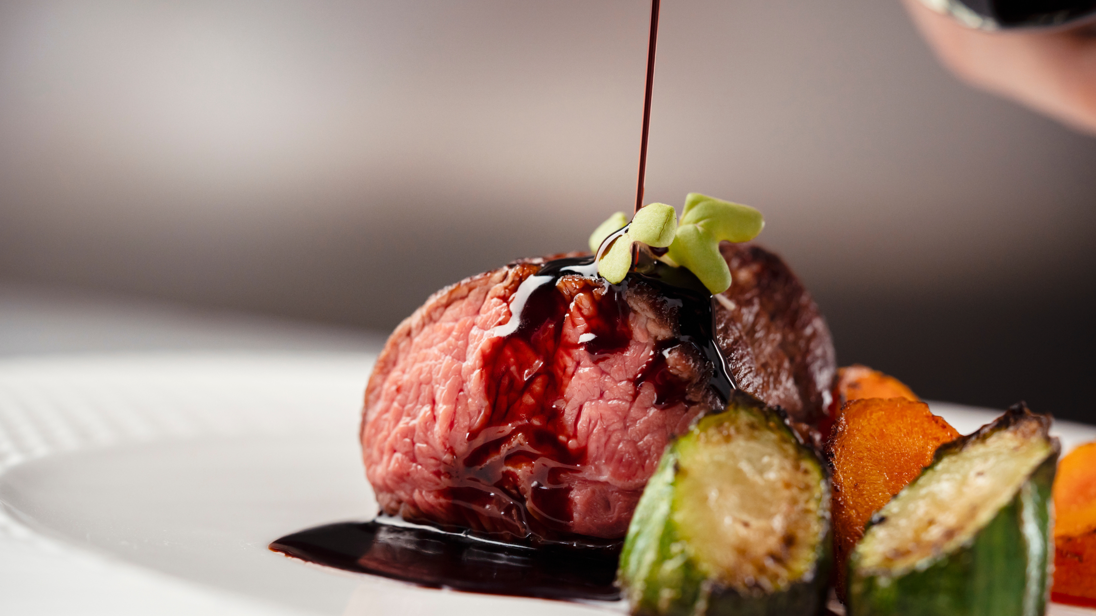 Verso un filo di aceto balsamico su un succulento filetto, accompagnato da verdure arrostite per un tocco di tradizione modenese.
