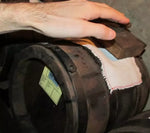 Una mano sfiora delicatamente una botte in legno, accanto a un candido panno piegato, evocando la tradizione vinicola.