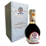 Scopri l'eleganza di una bottiglia di Aceto Balsamico Tradizionale di Modena, presentata in una scatola raffinata, simbolo di qualità e tradizione.