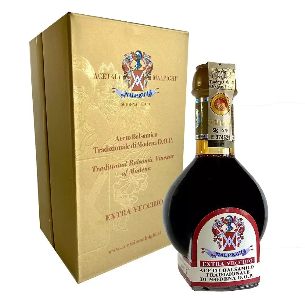 Una bottiglia sofisticata di Aceto Balsamico Tradizionale di Modena DOP, racchiusa in una confezione oro, rappresenta l'eccellenza secolare.
