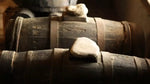 In una cantina soleggiata, antiche botti di legno ospitano l'Aceto Balsamico Tradizionale Reggio Emilia DOP in maturazione.