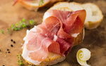 Crostini dorati accolgono affettato di culatello stagionato, impreziosito da erbe fresche e spezie aromatiche.