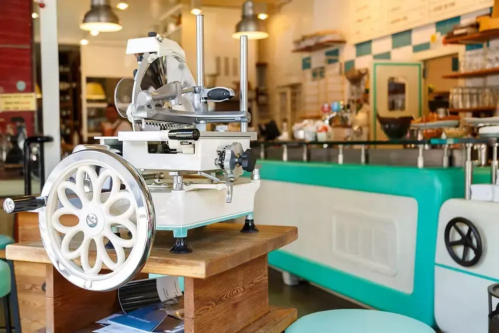 Un modello 300 di affettatrice a volano vintage si trova pronto per un uso preciso dei salumi in una cucina retrò accogliente.