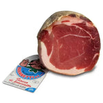 Un cesto di specialità pasquali con un prosciutto rosa, venato di bianco, pronto a rendere la tua tavola festiva ancora più deliziosa.