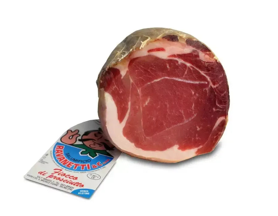 Immagine di un appetitoso fiocco di prosciutto, stagionato per 9 mesi, tagliato a metà con cotenna. L'etichetta è visibile, indicando la sua ricchezza di sapori tipici italiani.