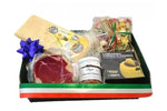 Un cesto regalo gourmet italiano, pieno di delizie come Parmigiano, prosciutto, sugo Amatriciana, pasta tricolore e un'elegante formaggiera.