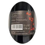 Una bottiglia di Primo Fiore Lambrusco, vino rosso frizzante Emilia IGT, si distingue su uno sfondo nero, decorato con fiori rossi per un tocco di eleganza.