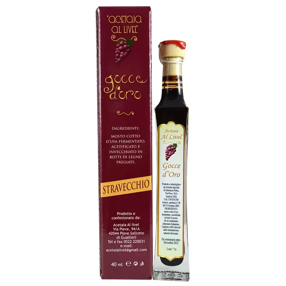 Una bottiglia di Gocce d'Oro, condimento balsamico stravecchio, dal design raffinato, è accostata a una scatola rossa con il logo di Acetaia Al Livel.