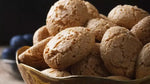 Primo piano su Amaretti Chiostro di Saronno: croccanti, dorati, friabili, posati su uno sfondo rustico che evoca tradizione.