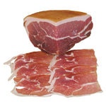 Una fetta di prosciutto crudo di Parma, finemente affettata e adagiata su un tagliere, ideale per un cesto natalizio gourmet.