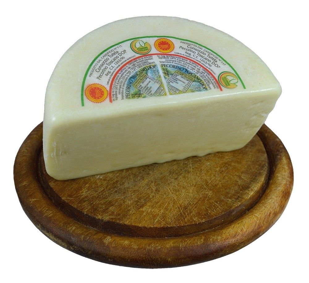 Uno splendido tagliere di legno ospita una metà di Pecorino Toscano DOP fresco, di colore bianco, con un'etichetta colorata.