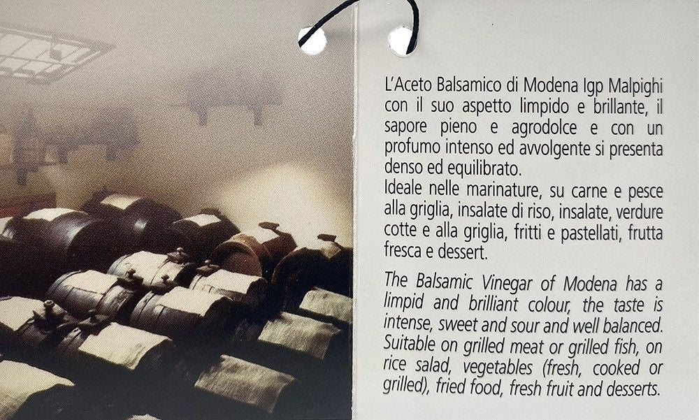 Un'etichetta raffinata svela l'Aceto Balsamico di Modena IGP, portatore di sapori robusti, perfetto per esaltare carne, pesce e dessert.