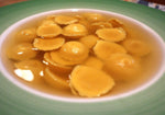 Anolini al Parmigiano Reggiano DOP fluttuano in un brodo caldo, evocando racconti di tradizione e maestria culinaria italiana.