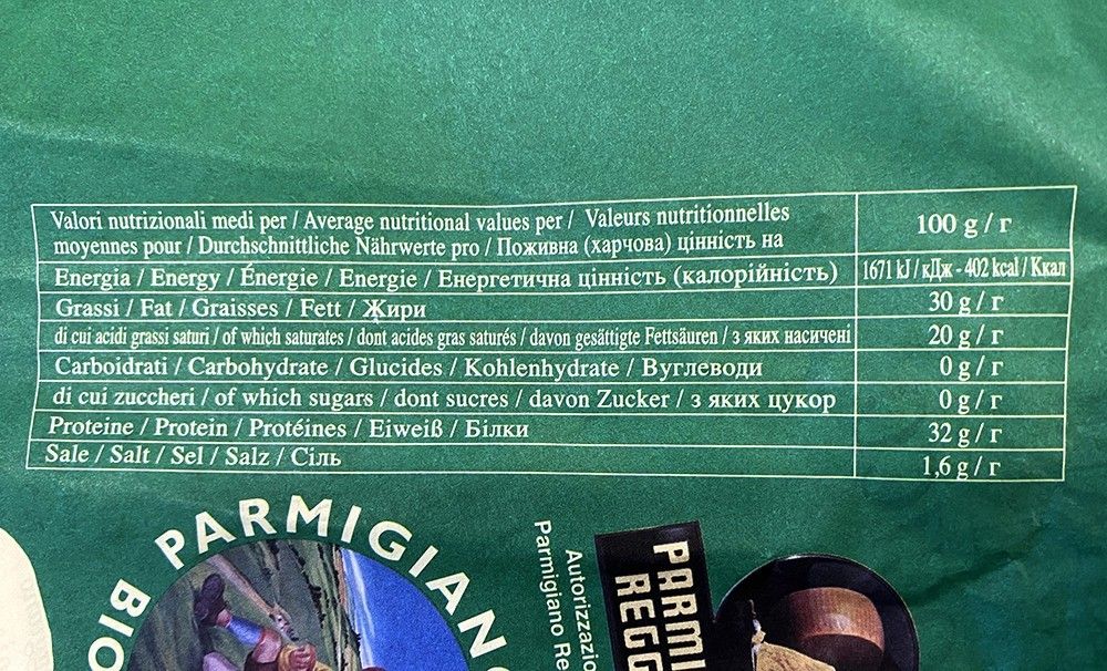 Un'etichetta di Parmigiano Reggiano Biologico di 60 mesi, mostra i valori nutrizionali in diverse lingue, con enfasi su calorie e grassi.
