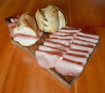 Un invitante panino con fette di autentica Mortadella di Bologna IGP, servito su un rustico tagliere in legno per uno spuntino all'italiana.