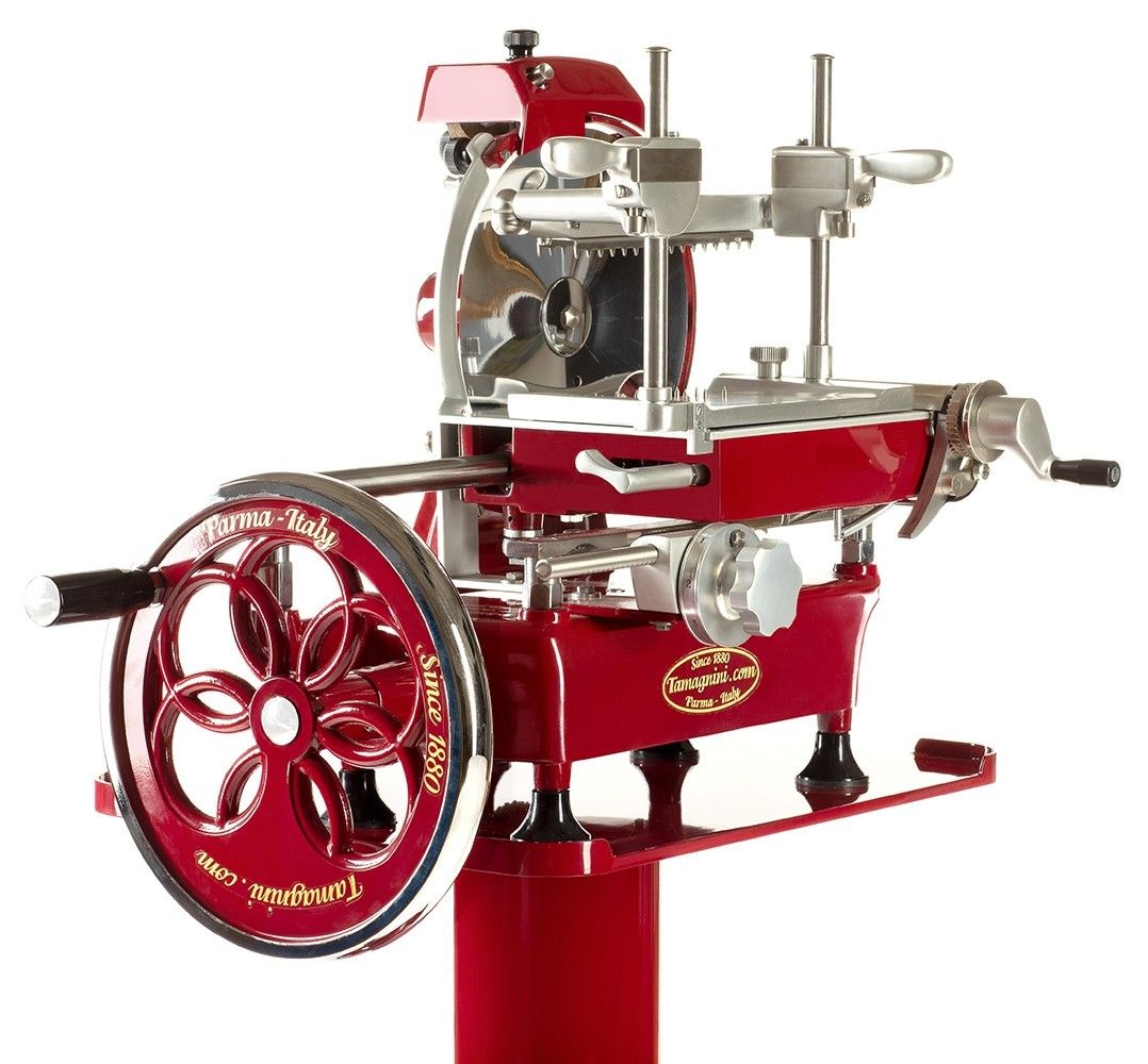 Affettatrice manuale rossa dal design vintage, ideale per un taglio preciso senza bisogno di elettricità, perfetta per contesti rustici.