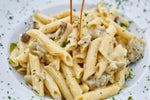Un piatto gourmet di pasta cremosa, arricchito da funghi porcini secchi e un tocco di prezzemolo fresco, irresistibilmente invitante.