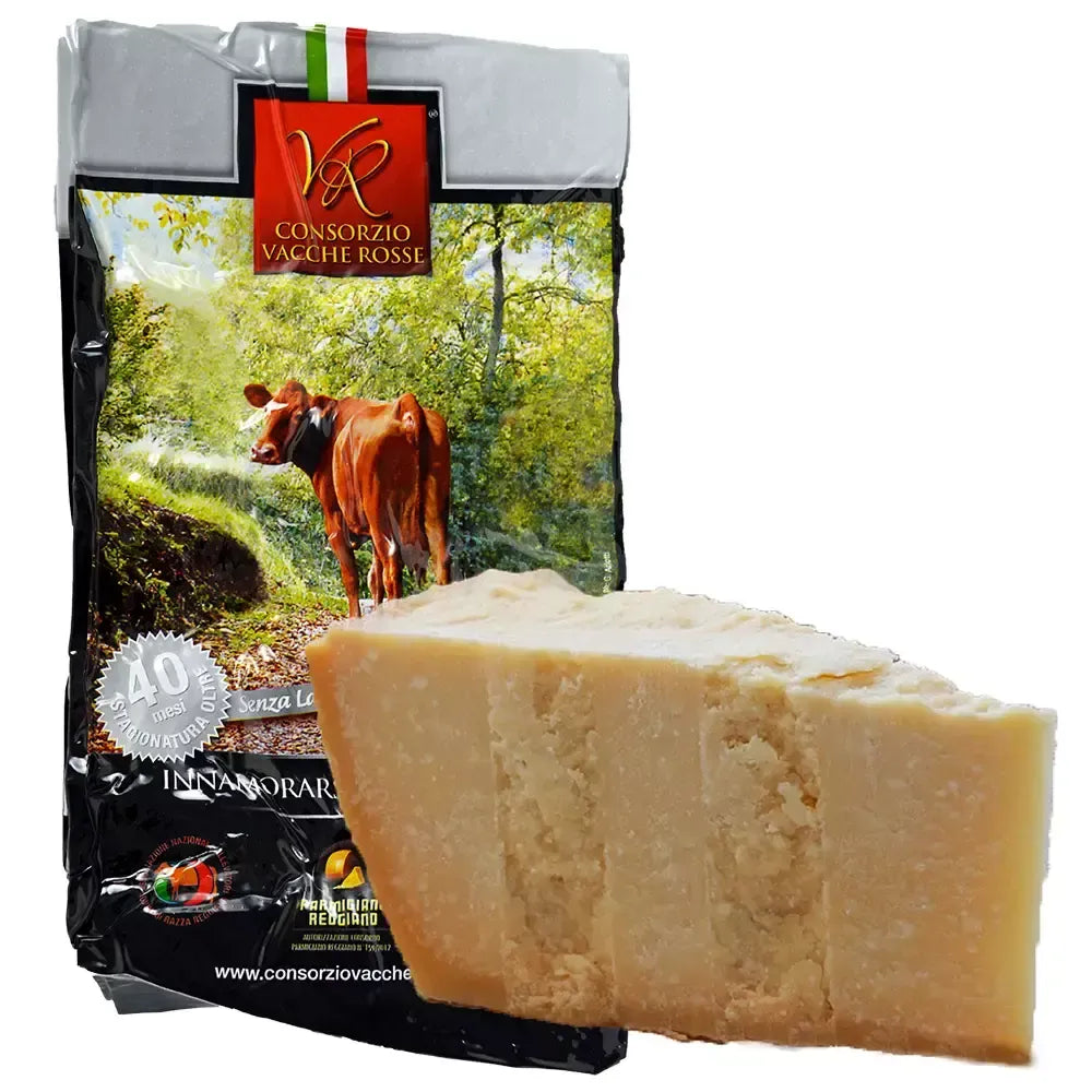 Formaggio Parmigiano Reggiano Vacche Rosse stagionato per 40 mesi, dal sapore intenso, presentato in una confezione che ritrae una verde campagna.