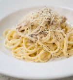 Un piatto di pasta cremosa, arricchito da pepe e pecorino stagionato, offre un sapore autentico ed avvolgente all'italiana.