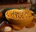 Deliziosi gnocchi dorati, serviti in una mezza forma di Parmigiano Reggiano stagionato 24 mesi, arricchiti con salvia e accompagnati da coltelli e formaggio grattugiato.
