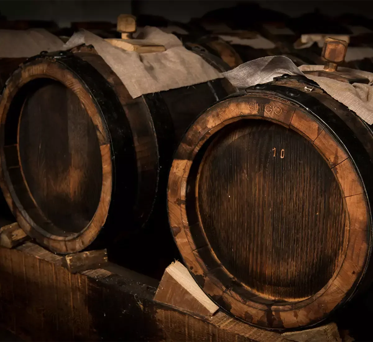 Old wooden barrels preserve the ageing of the precious PDO balsamic vinegar of Modena, spreading a scent rich in history and authenticity.