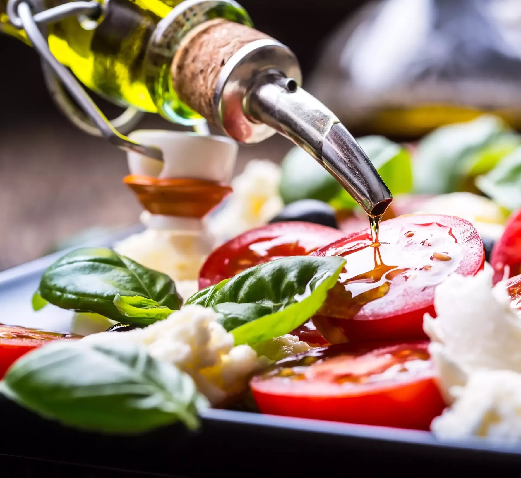 Una lattina di olio extra vergine d'oliva che si riversa su pomodori freschi e basilico, esaltando la vivacità e i sapori del Mediterraneo.