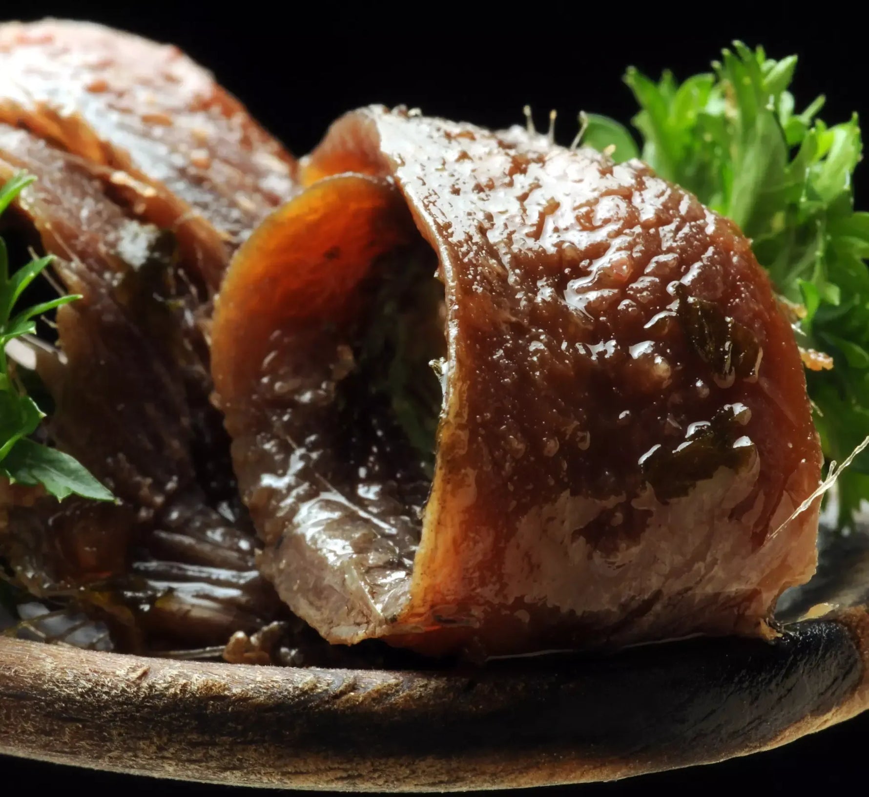Alici succulente in salsa piccante, servite su un piatto dall'aspetto rustico, arricchite da erbe fresche per un sapore vivace e avvincente.