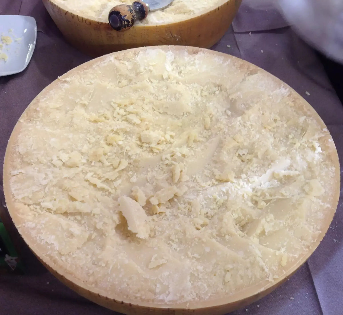 Un autentico pezzo di Parmigiano Reggiano DOP stagionato per 24 mesi, servito con tre coltelli dedicati per un'esperienza gourmet raffinata.