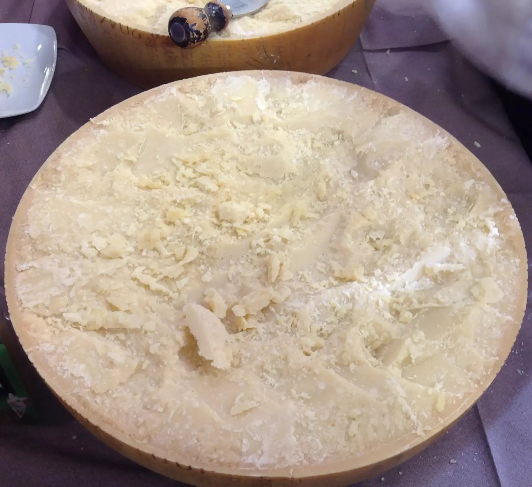 Un autentico pezzo di Parmigiano Reggiano DOP stagionato per 24 mesi, servito con tre coltelli dedicati per un'esperienza gourmet raffinata.