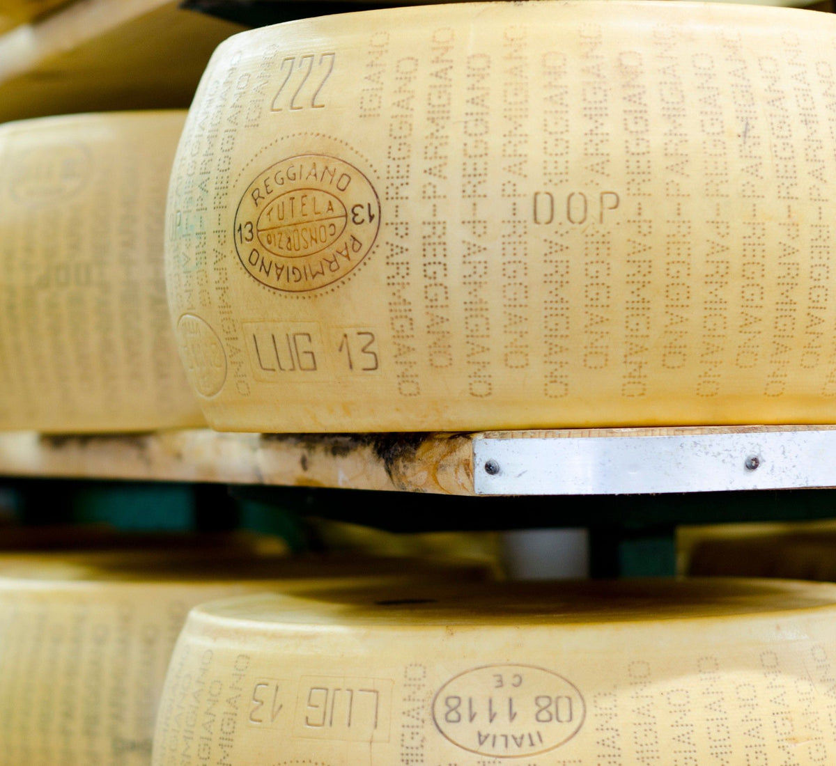 Un pezzo intero di Parmigiano Reggiano DOP stagionato 24 mesi, esposto su uno scaffale, con un coltello professionale accanto.