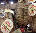 Un autentico Culatello di Zibello DOP stagionato, legato con corde, e dotato di etichette attestanti la sua autenticità e qualità artigianale.