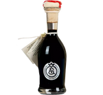 Un'immagine ritrae un'elegante bottiglia di Aceto Balsamico Tradizionale di Reggio Emilia DOP, sigillata con ceralacca rossa, simbolo di prestigio.