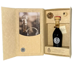 Una bottiglia artigianale di Aceto Balsamico Tradizionale di Reggio Emilia DOP Argento sigillata con un rosso distintivo, presentata in un'elegante confezione regalo.