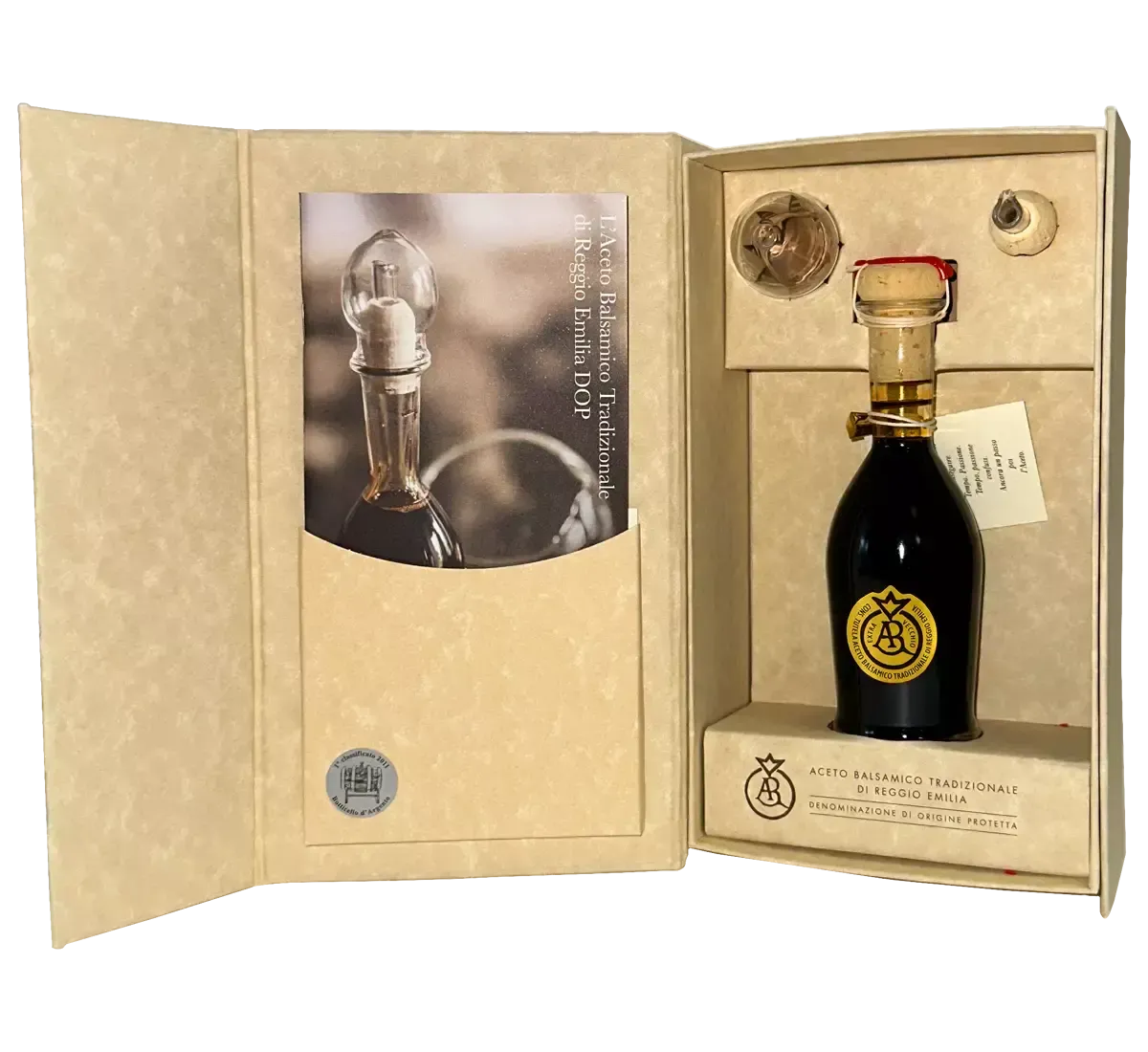 Una scatola aperta rivela una bottiglia di Aceto Balsamico Tradizionale Reggio Emilia DOP Oro, con un sigillo rosso e un'etichetta raffinata.