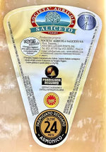 Una mezza forma di Parmigiano Reggiano DOP, stagionato per 24 mesi, proveniente dalle montagne. L'etichetta fornisce dettagli precisi e l'acquisto include tre coltellini per la degustazione.