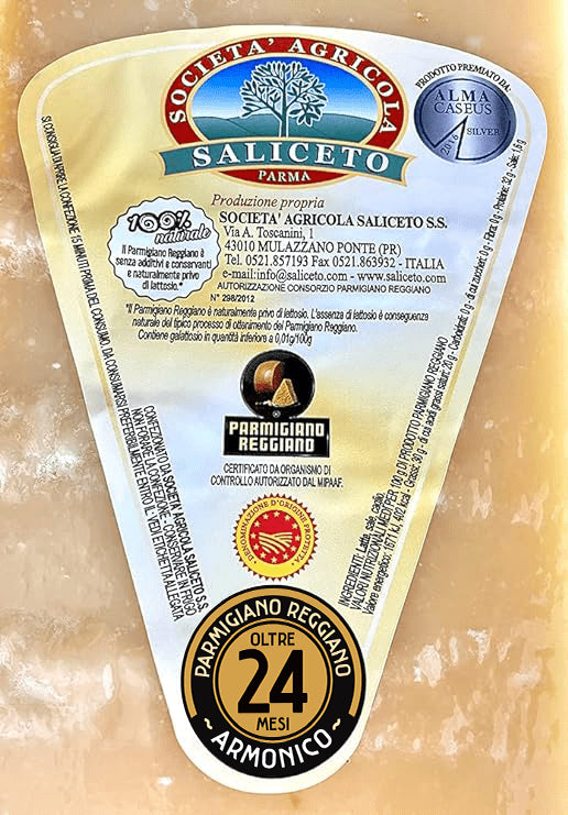 Un intero Parmigiano Reggiano DOP di Montagna, stagionato per 24 mesi; con etichetta visibile e un coltello professionale incluso. Qualità artigianale in evidenza.