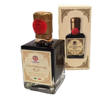 Condimento balsamico Modena IGP presentato in una bottiglia dall'eleganza raffinata, sigillata con ceralacca rossa e caratterizzata da un'etichetta storica e una confezione dal tocco vintage.