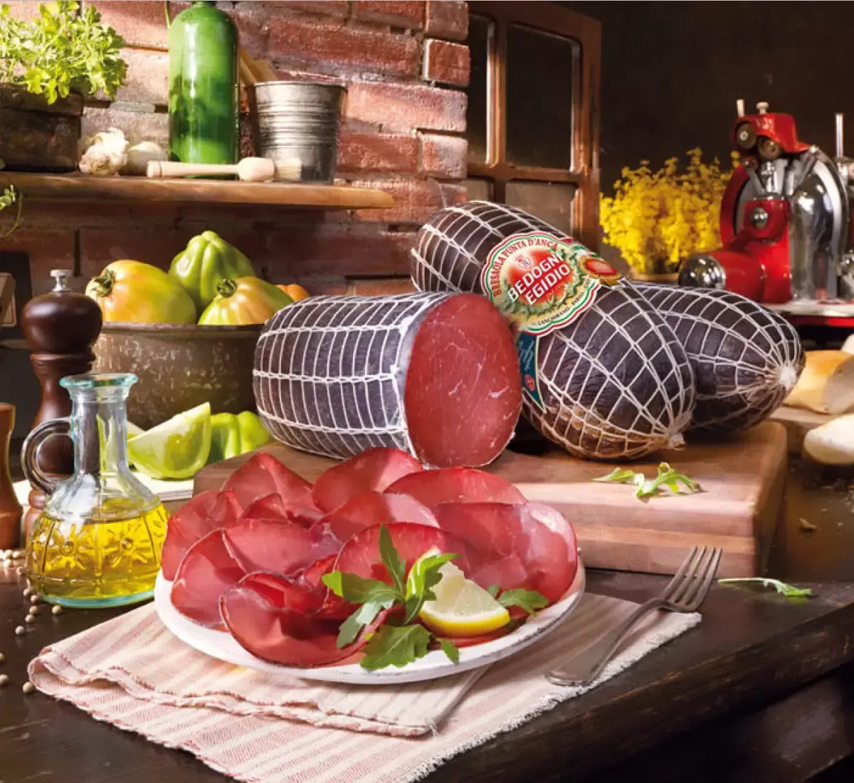 Metà di una bresaola di manzo Punt'Anca, posta su una tavola rustica, abbellita da agrumi e olio, ideale per un sofisticato antipasto.