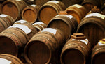 Antiche botti di legno custodiscono con cura il pregiato aceto balsamico di Reggio Emilia DOP, simbolo di tempo e tradizione artistica.