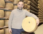 Pezzo di Parmigiano Reggiano Vacche Rosse biologico, stagionato per 24 mesi, posato in un deposito montano.