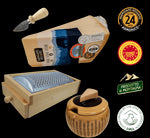 Un formaggio Parmigiano Reggiano DOP, stagionato per 24 mesi, presentato con una grattugia in legno, un coltello, una ciotola e il marchio montagna.