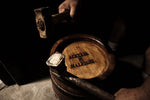 Artigiani esperti lavorano con cura una botte di autentico aceto balsamico di Modena DOP, esprimendo artigianalità e tradizione.
